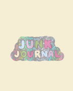 Sticker coloré affichant JUNK JOURNAL en lettres rondes pastel sur un fond nuageux pour carnets et journaling par Nany Craft Shop