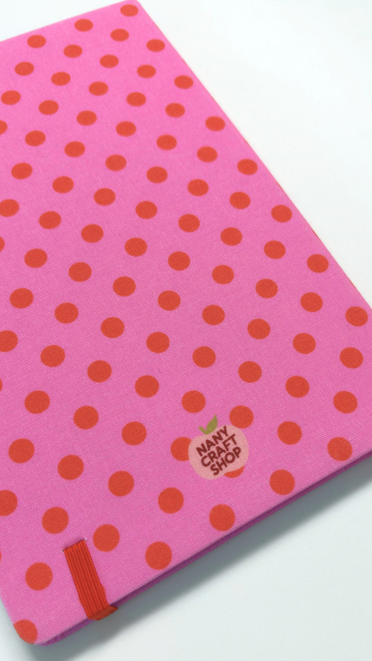 Carnet rose à pois rouges avec élastique rouge et logo Nany Craft Shop pour le journaling et la papeterie créative