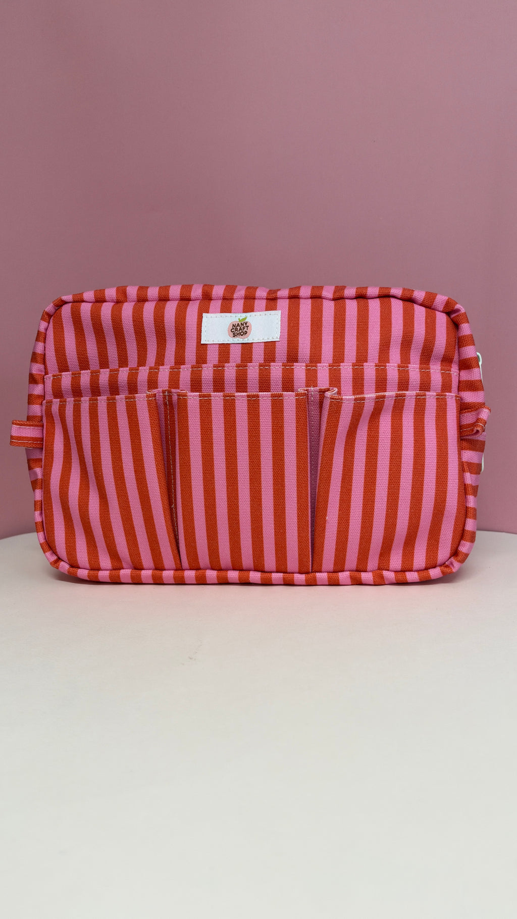 Pochette grenadine à rayures rouges et roses avec poche avant zippée présentée par Nany Craft Shop dans la collection tous les produits