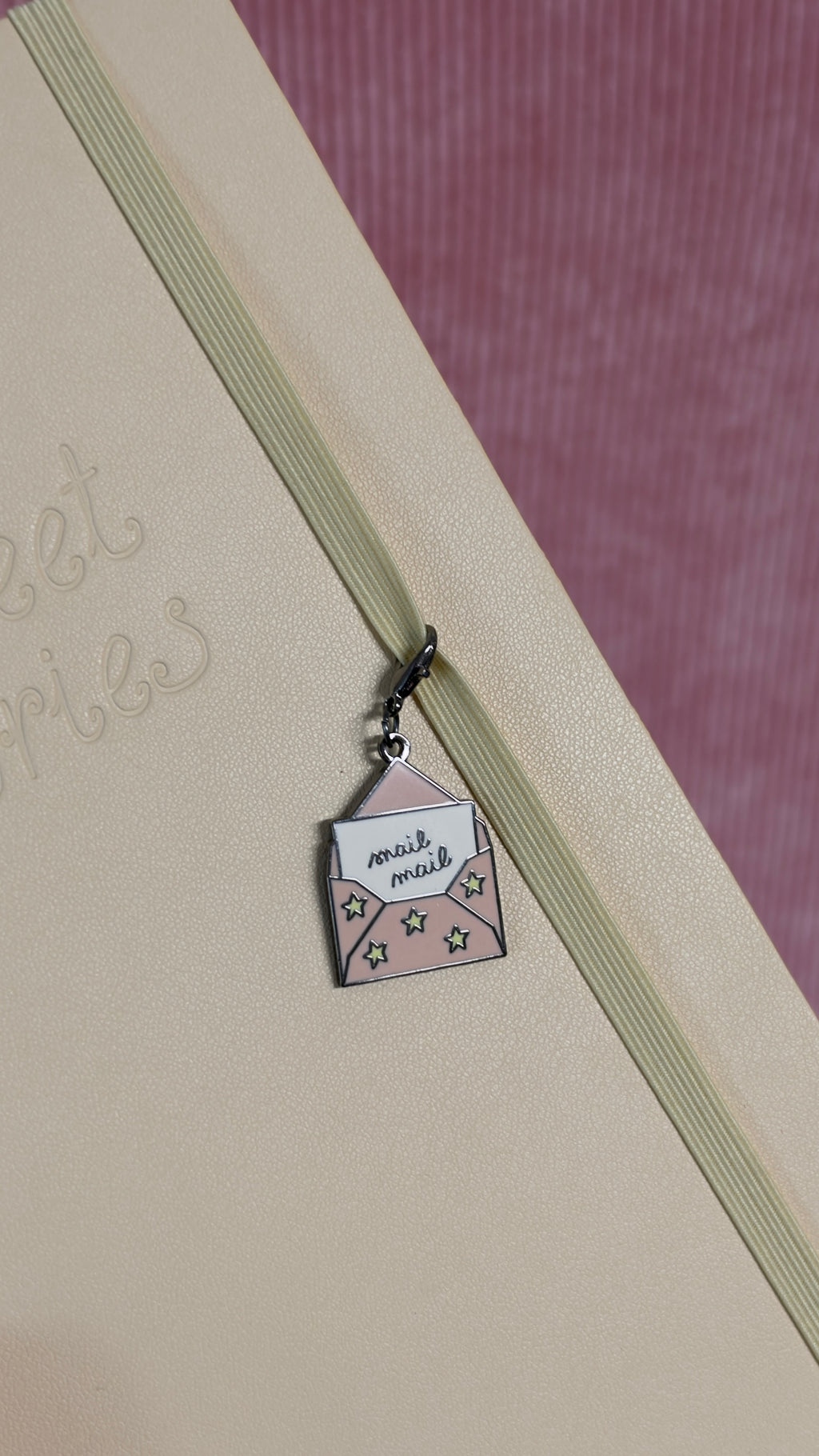 Petit charm en forme d enveloppe rose accroche a l elastique d un carnet beige avec motifs etoiles par Nany Craft Shop tous les produits
